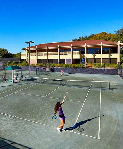 A woman serving on a tennis court