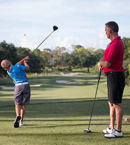 A father and a son playing golf