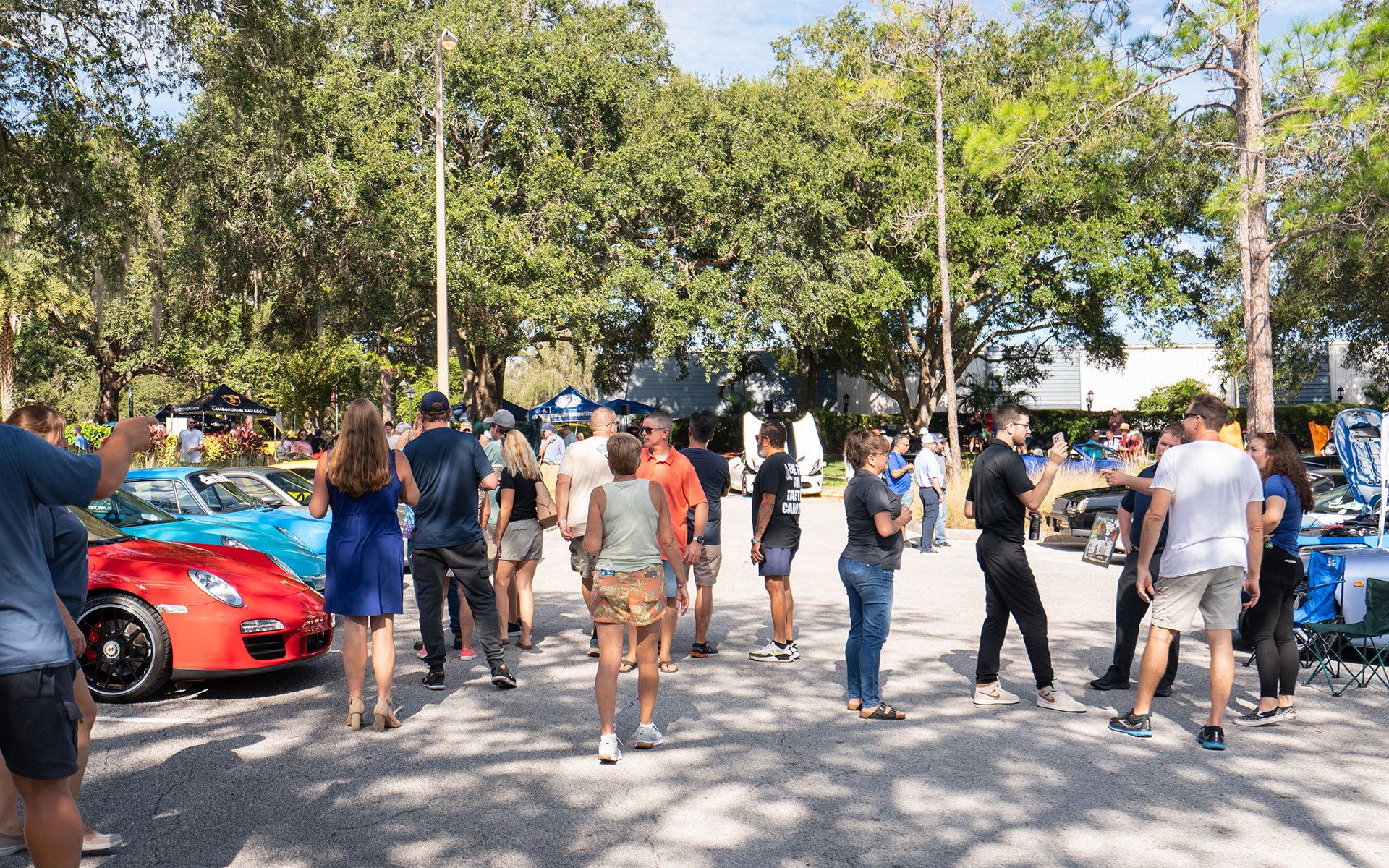 A crowd of people around sports cars