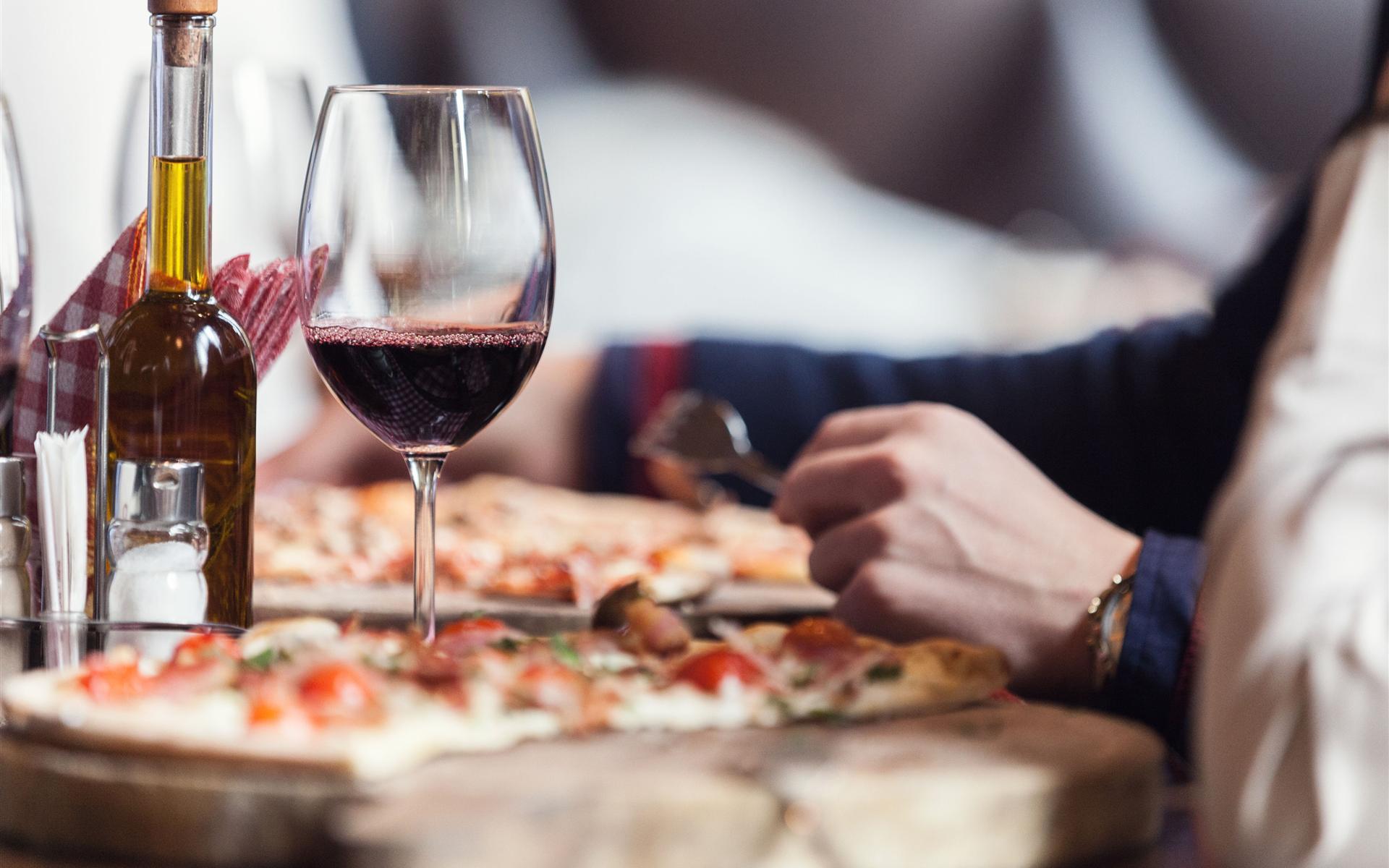 A glass of wine and pizza