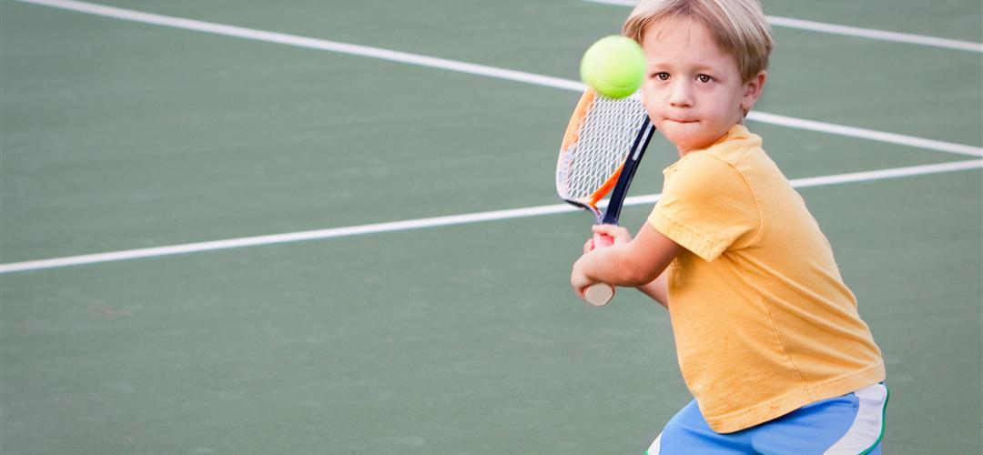 A kid playing tennis