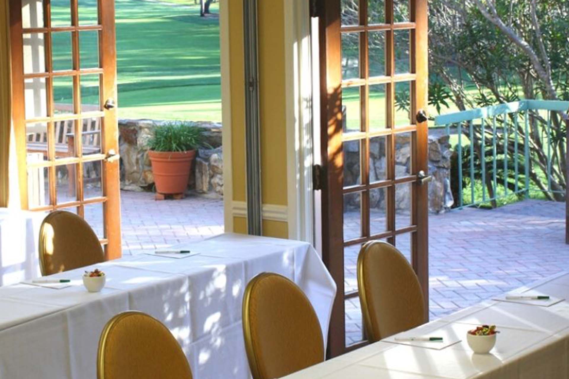 Long tables in a room with doors that open to the outside