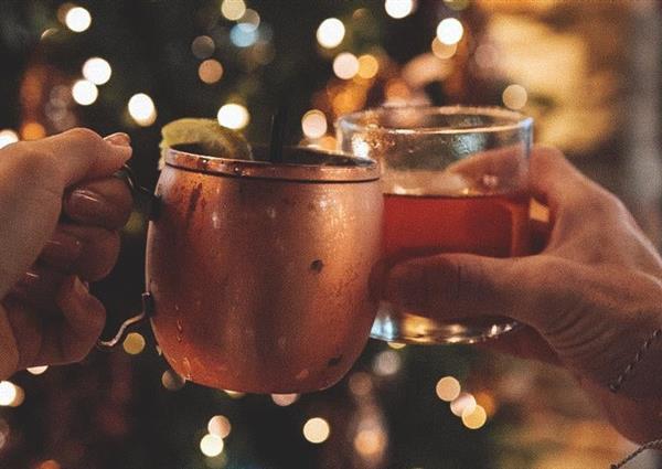 Beverages cheers in front of Christmas Tree
