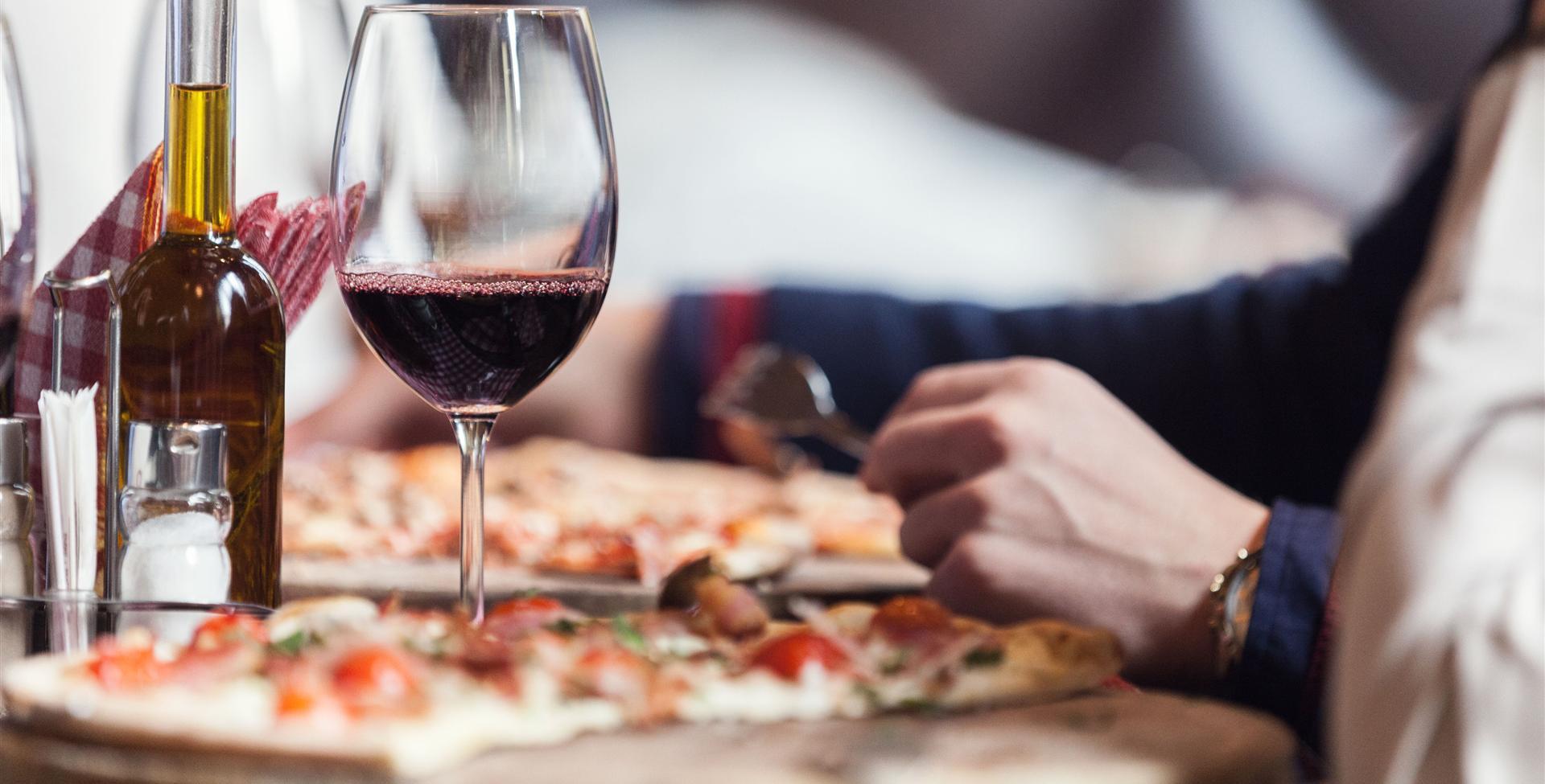 A glass of wine and pizza