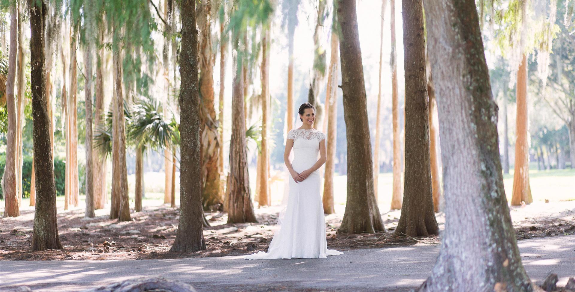 A bride standing in the woods