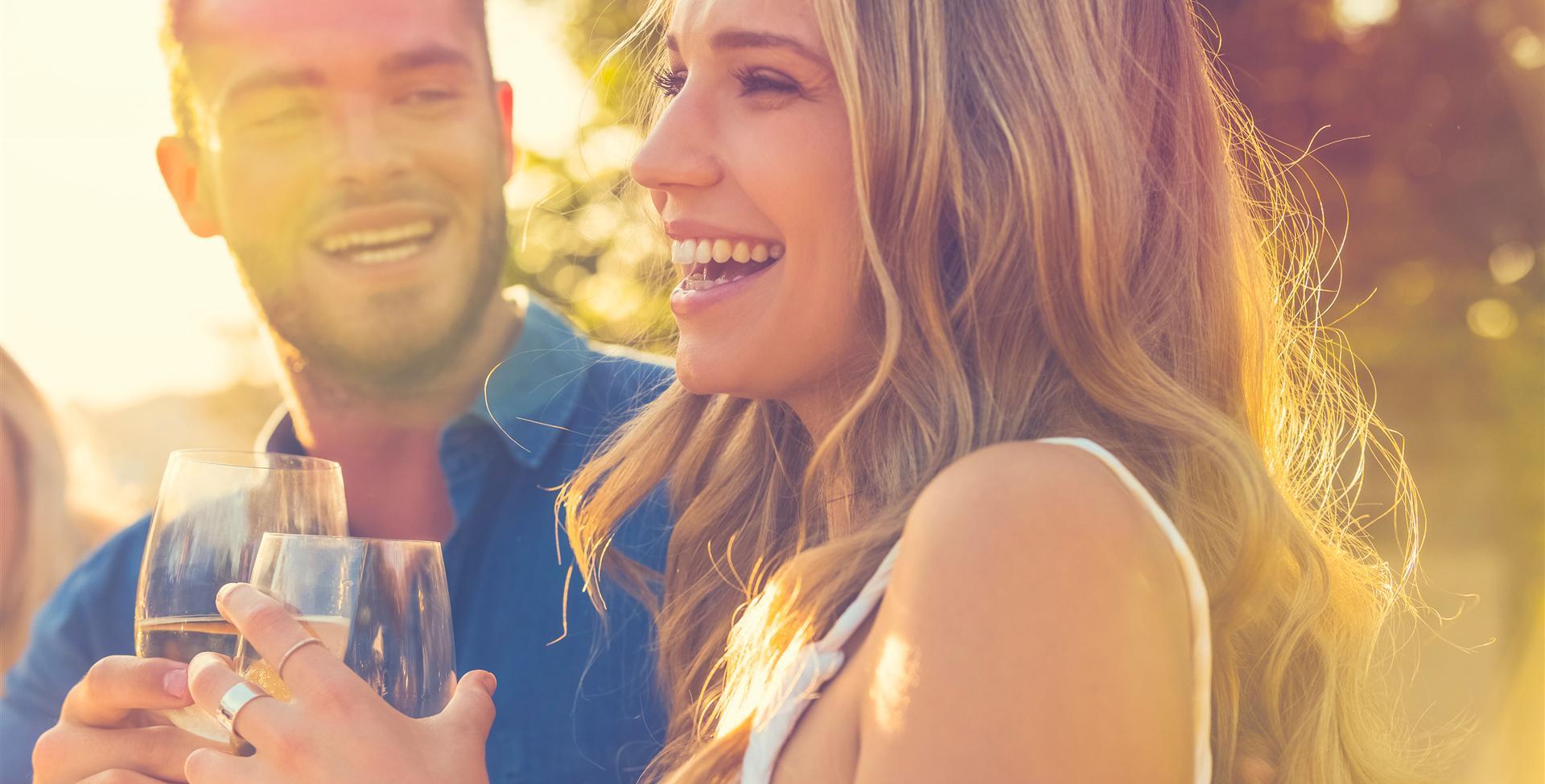 Two people smiling with beverages in hand